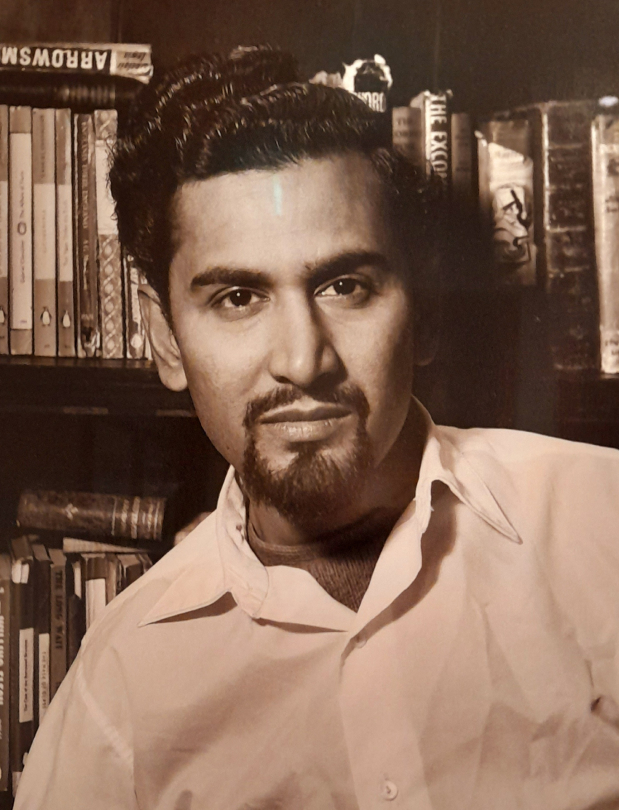 Man stood in front of bookshelf